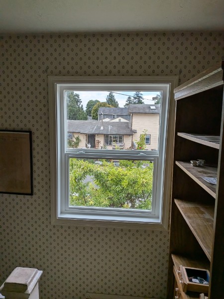 White double-hung window looking out over neighboring Washington rooftops
