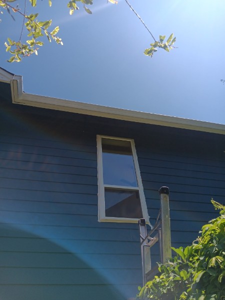 Finished single-hung window on dark blue siding