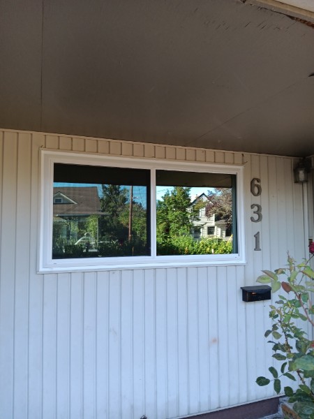 Installer at the door of a cream house with new windows above
