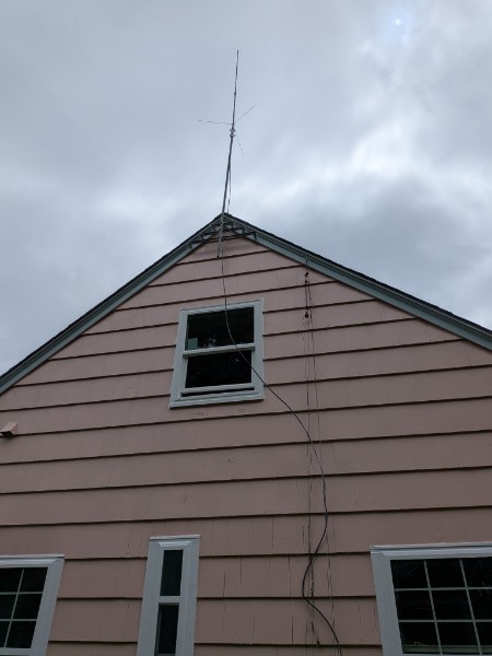 White double-hung in the gable of a pink shake house