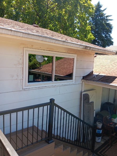 Slider window on a white ranch seen from a stair landing